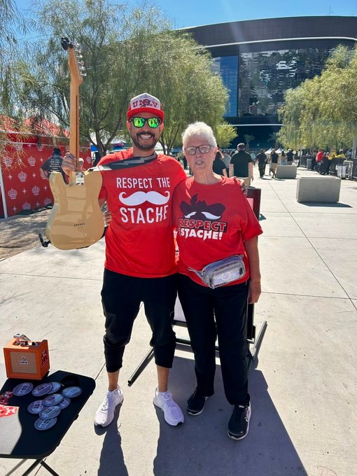 Fans in Respect the Stache shirts beside a Hey Reb! mural